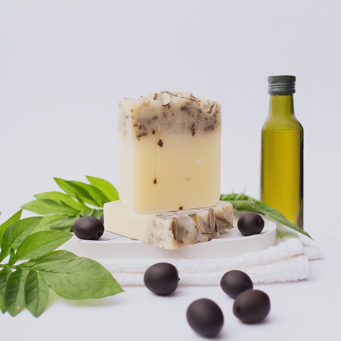Olive Oil Soap - Lifestyle next to olive oil bottle and black olives